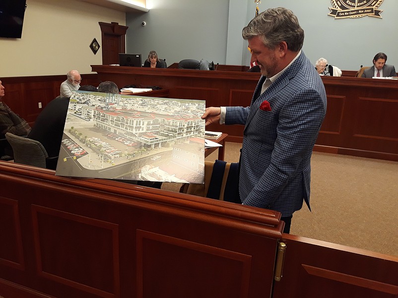 Developer Christopher Glancey shows off an architectural rendering of the proposed Ludlam hotel project.