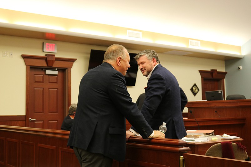 Hotel developers Bob Morris, left, and Christopher Glancey confer during a break in the meeting.