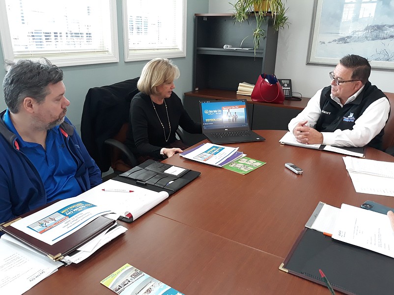 Representatives of the Sea Isle City Tourism Commission watch a web commercial that is part of the summer marketing campaign.