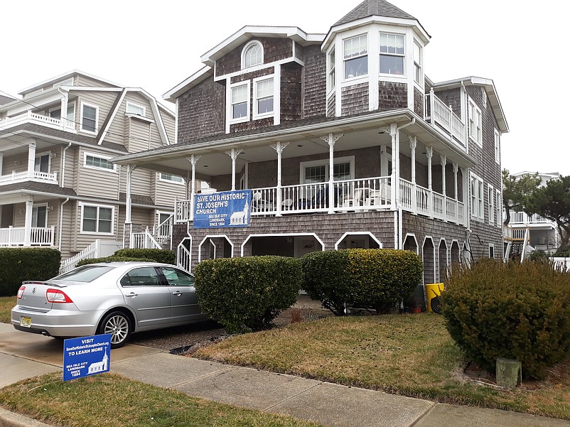 Preservationist Andy Bednarek's home on 55th Street includes a banner and sign proclaiming "Save Our Historic St. Joseph's Church."