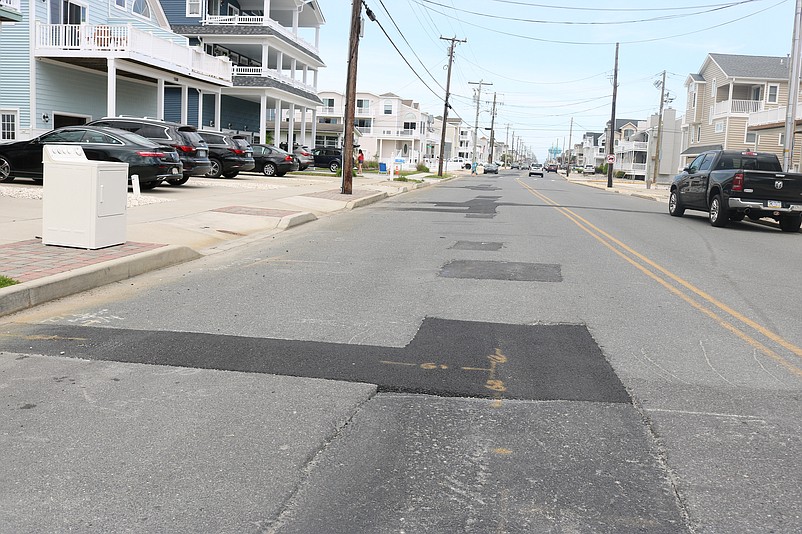 A look down Central Avenue shows a series of temporary asphalt patches in the middle of the road.