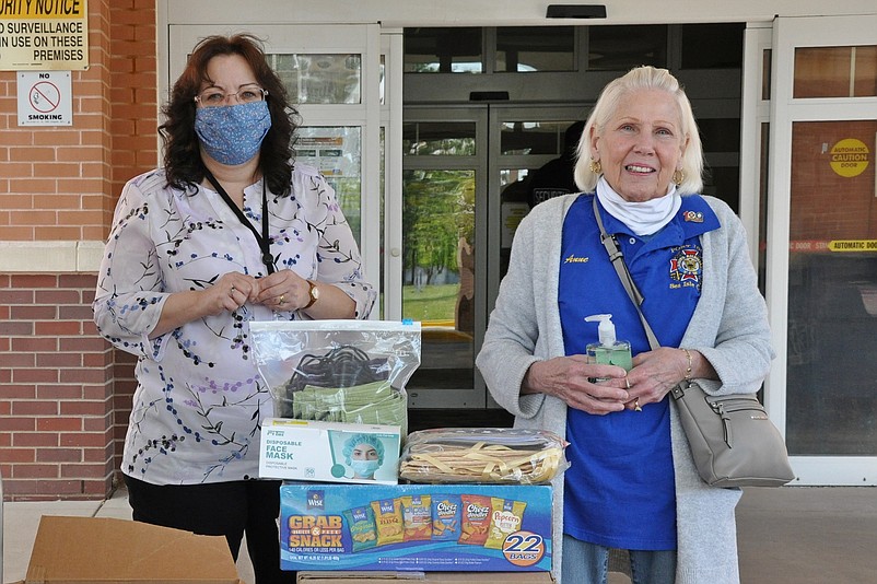 VFW Post 1963 Auxiliary Secretary Anne Devitt, right, makes a donation to an employee of the Vineland Veterans Home.