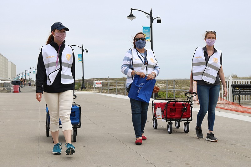 From left, Megan Santiago, Eleanor Forte and Liberty Kocis, all with the "Six Feet Saves" campaign, walk along Sea Isle's Promenade.