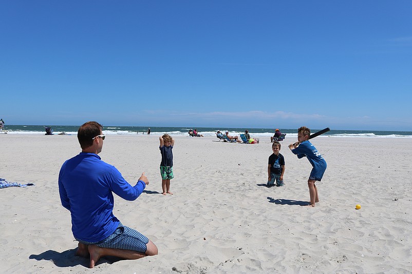 David Will, of Havertown, Pa., plays ball on the beach with his sons, David Jr., James and Patrick.