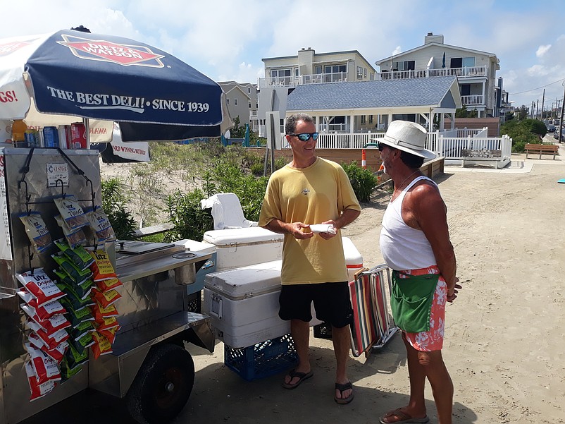 Bernie Booth, right, owner of Bernie's Beach Dogs, plans to keep his  hotdog stand at 85th Street, open longer this year because of the influx visitors expected in the early fall.