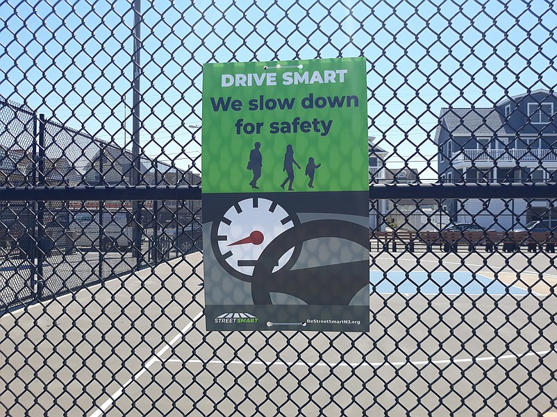 One sign that is part of the pedestrian safety program urges motorists to slow down.