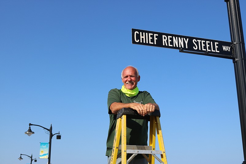 Sea Isle City Beach Patrol Chief Renny Steele climbs a ladder to get a close look at the sign that honors him.