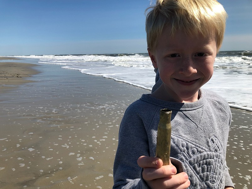 Will Edwards, 6, holds up an empty shell casing found on the 80th Street beach Tuesday. (Photo credit Melissa Edwards)