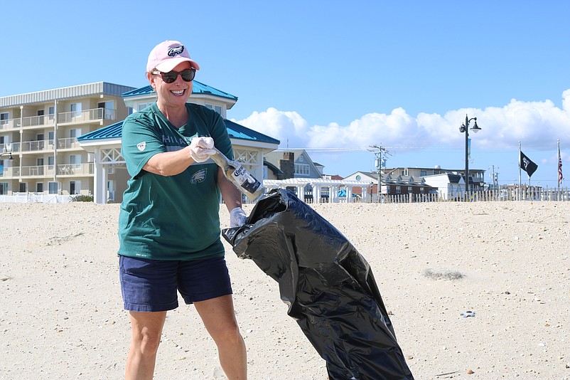 Berkshire Hathaway sales agent Tracey Yarborough collects litter on the Sea Isle City beaches as part of the company's cleanup day. 