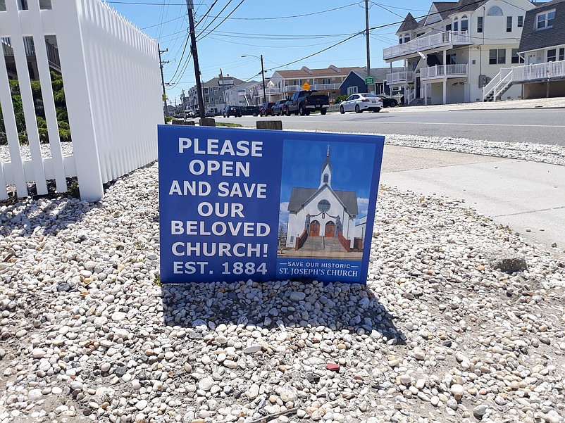 Blue lawn signs like this one are scattered around town in support of saving the old church.