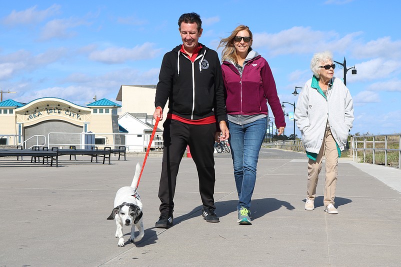 Mt. Laurel family Rick and Debbie Eddy, and Anna Cummings, give Scarlett, their rescue pup, a stroll down the Promenade. 