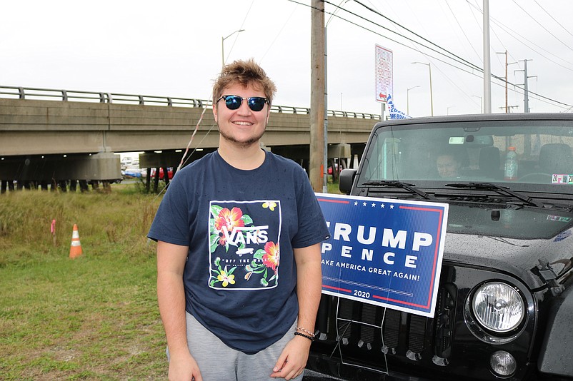 Will West, 20, of Downingtown, Pa., stands in front of his Jeep with the political sign attached to it.