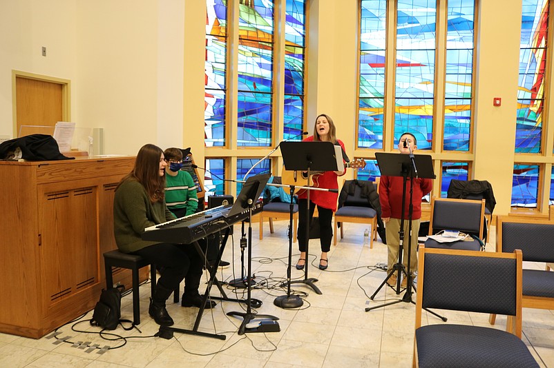 Judi DiBabbo, standing, is joined by her children, Ava, John and Michael, during a song at Christmas Mass.