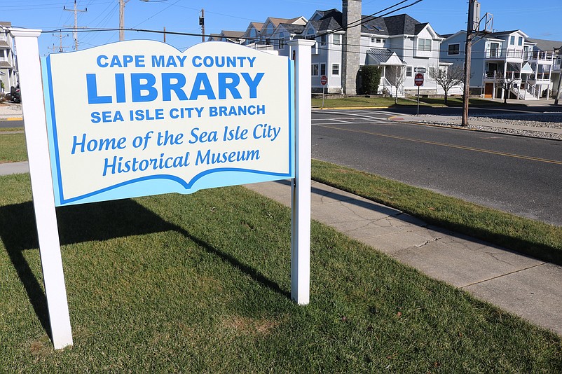 The cracked sidewalk is visible to the right of the Cape May County Library sign overlooking Central Avenue near 48th Street.