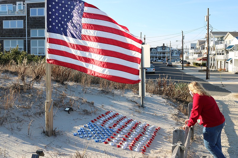 Cindi Boone, of Carneys Point, N.J., admires the display of red, white and blue clam shells along the pathway to the beach at 84th  Street.