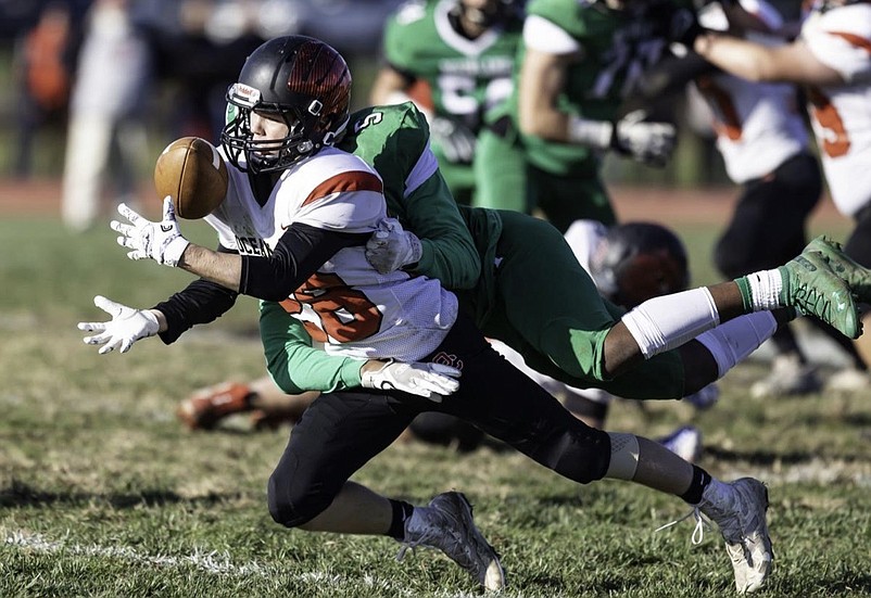 Jack Schneider , wearing No. 28 as an underclassman, hauls in a pass against Mainland.