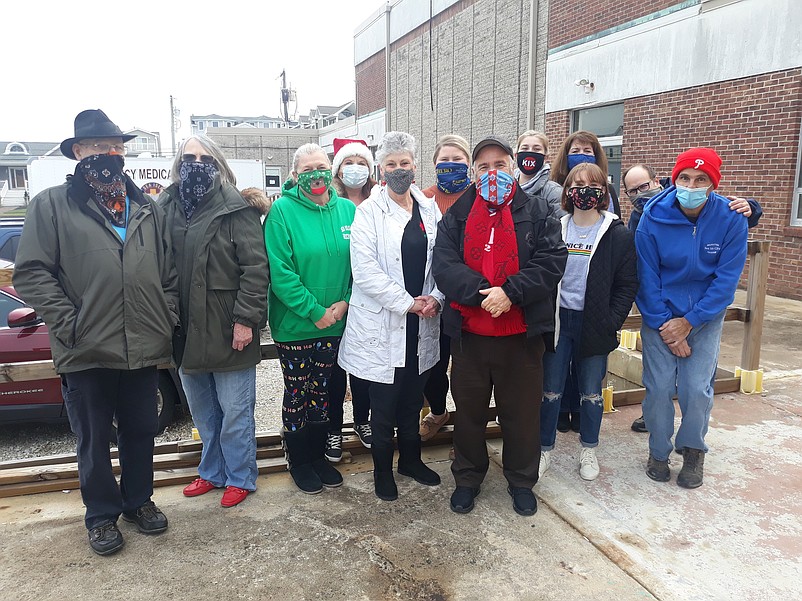 Sis Borden, center, in white coat, wraps the gifts each year and is one of the volunteer "elves" who help out with the toy and food drive.