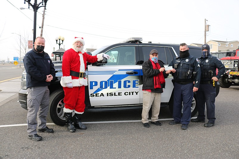 Mayor Leonard Desiderio, center, accepts a $1,200 donation for his annual Holiday Toy &amp; Food Drive from Sgt. Steve Jankowski and Sgt. Rob Scarano, while Police Chief Tom McQuillen and Santa Claus watch the check presentation ceremony.