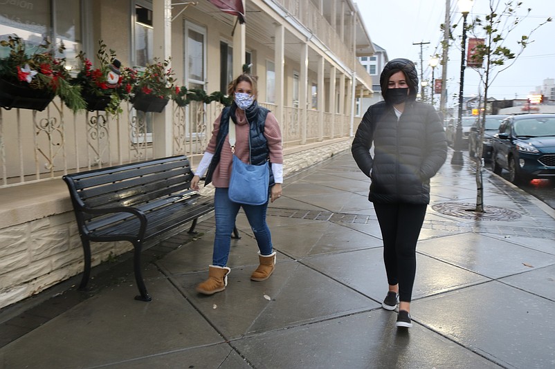 Sea Isle residents Michelle Rebock, left, and her daughter, Morgan, brave the wind and rain while walking down the sidewalk along Landis Avenue.