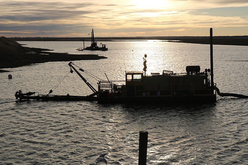 As sunset arrives, a big dredge is positioned in the middle of the channel next to the Yacht Club of Sea Isle City.