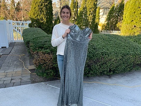 Ocean City High School senior Stephanie Carey holds up a gown available for free. (Photo courtesy of the Carey family)