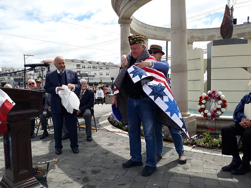 Vietnam War veteran Harry Strack is ceremonially wrapped in a Quilt of Valor by Kathy Tweed, a representative of the South Jersey Quilts of Valor Foundation.