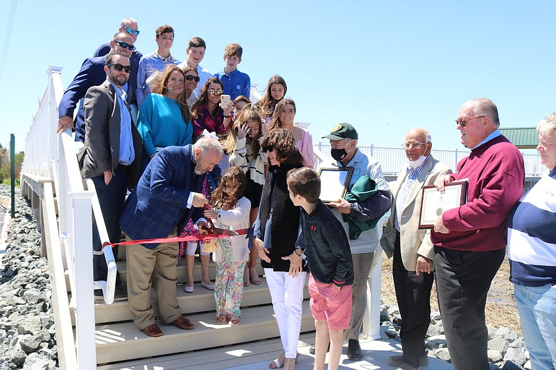 Mayor Leonard Desiderio receives help from 6-year-old Vivian McDonald, Jim Iannone's granddaughter, in cutting the ceremonial ribbon to open the new pier.