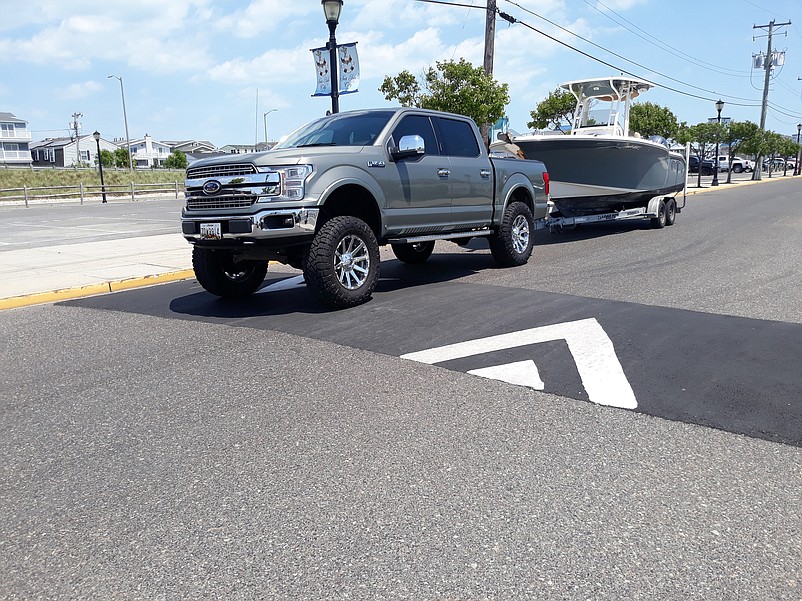 A truck pulling a boat passes over one of two new speed humps that have been put on 42nd Place to slow down traffic.