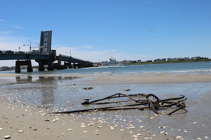 What appear to be cables or twisted pieces of metal litter the beach near the water's edge.