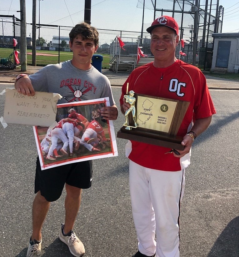 Coach Andrew Bristol holds up the championship plaque.