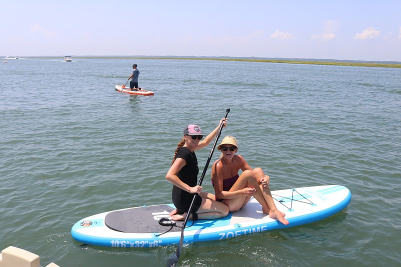 Sisters Emily and Lizzy McGowan paddle out in the calm waters of the back bay.