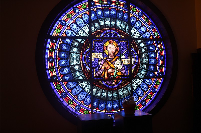 A stained-glass window on the second floor depicts the image of St. Joseph.