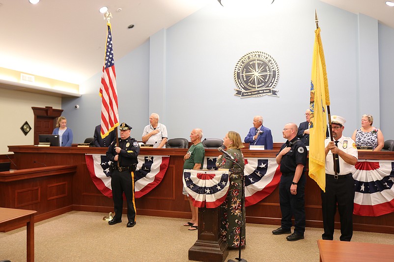 Council members and other city officials lead the audience in the Pledge of Allegiance.