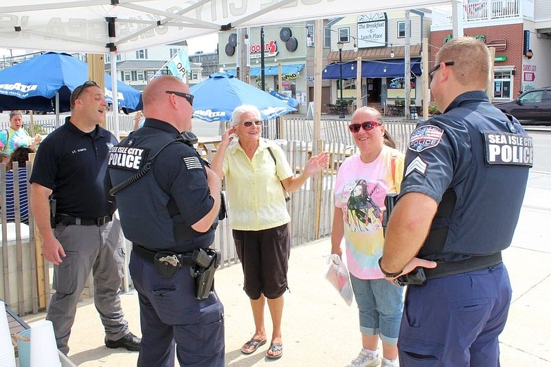 Police Chief Tom McQuillen, center, and other officers meet with the public during a "Coffee With Cops" outing on Aug. 19 at Shorebreak Cafe. 