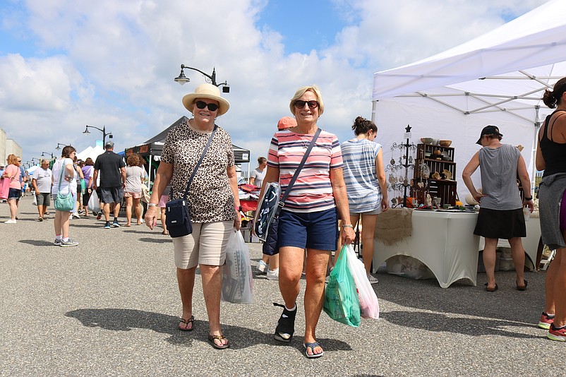 Sisters-in-law Susan Toto, left, and Nancy Toto take in some shopping at the vendors lining the Promenade.