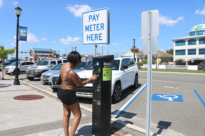 Jasmine Scott, of Philadelphia, uses one of the kiosks on Labor Day, the last day before free parking. 