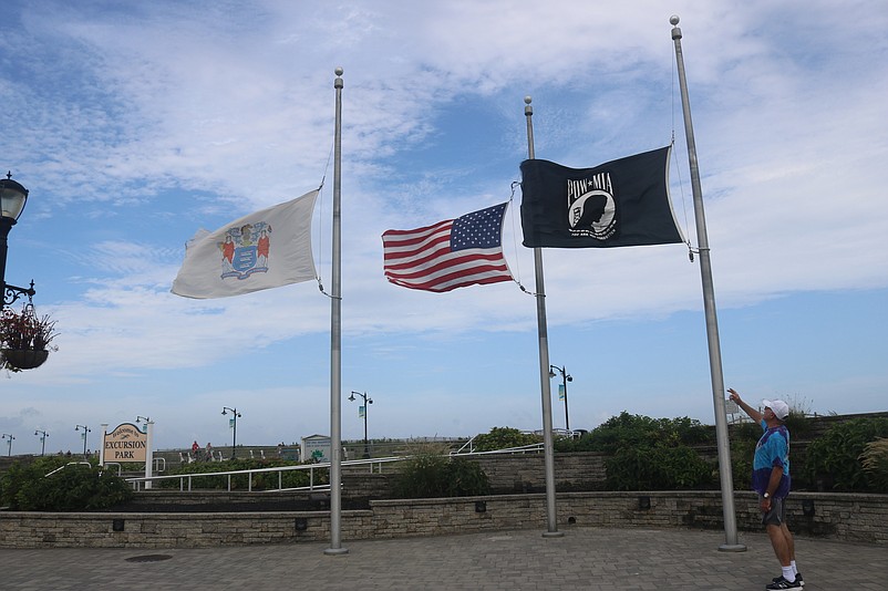 Joe Ford, a summer resident of Sea Isle, points to the flags whipping in the winds.