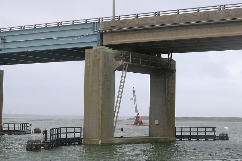 Dredging equipment seen off in the distance between the bridge piers is ready to be used again.