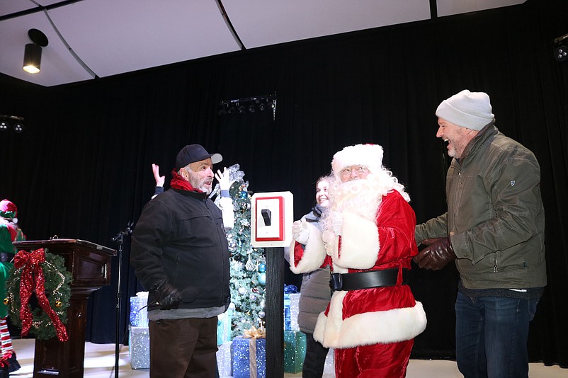 Santa flicks the switch to light the holiday tree while flanked by Mayor Leonard Desiderio and Sea Isle businessman Christopher Glancey.