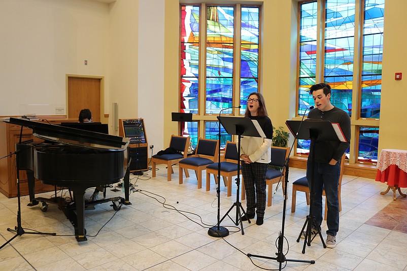 Singers Colleen Pond and her son, Matt, are accompanied by pianist Andrew Hink while performing Christmas music inside the church.