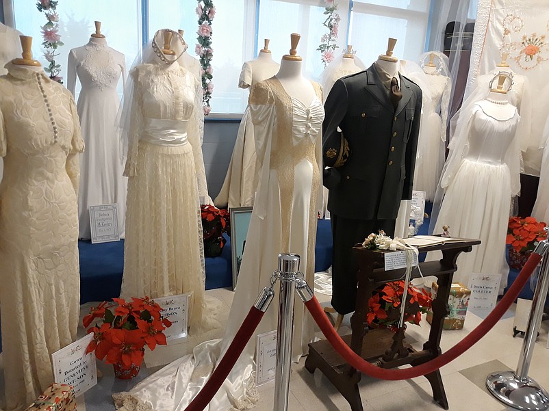 Poinsettia plants add some color to a display of vintage wedding gowns once worn by Sea Isle City brides.