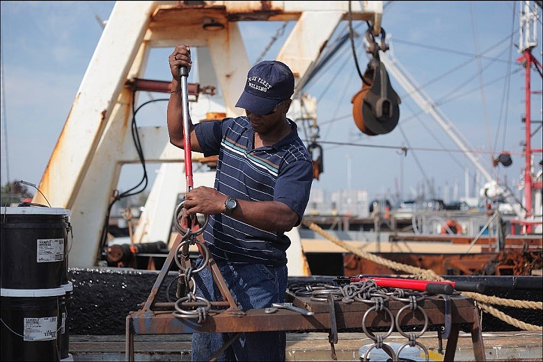 A worker tends to scallop gear in New Bedford Harbor. The Atlantic scallop industry is the most economically valuable wild-caught federal fishery in the highest value fishing port in the nation. (Credit: New Bedford Port Authority)