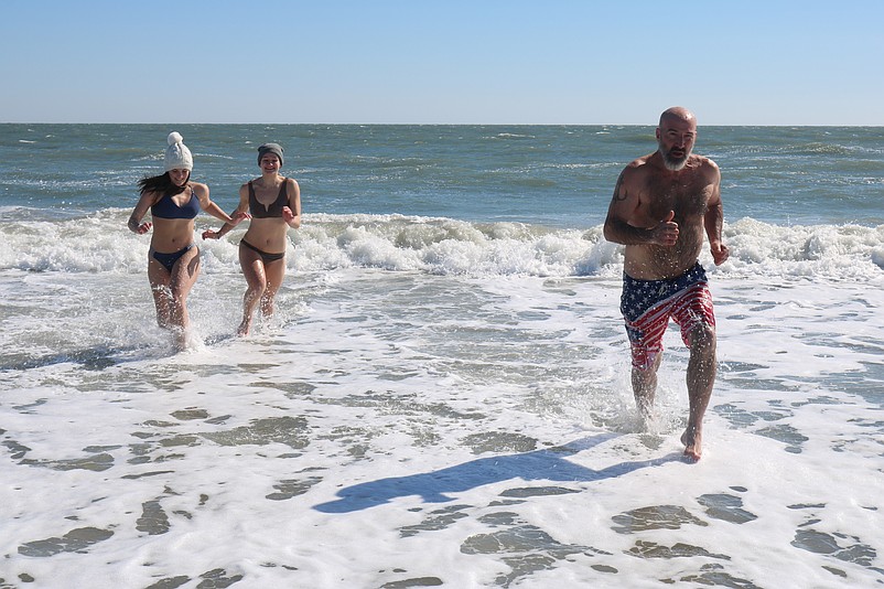 Charlie Brayerton is followed out of the water by his daughter, Karli, and her friend, Emileigh Zane, after their chilly plunge.