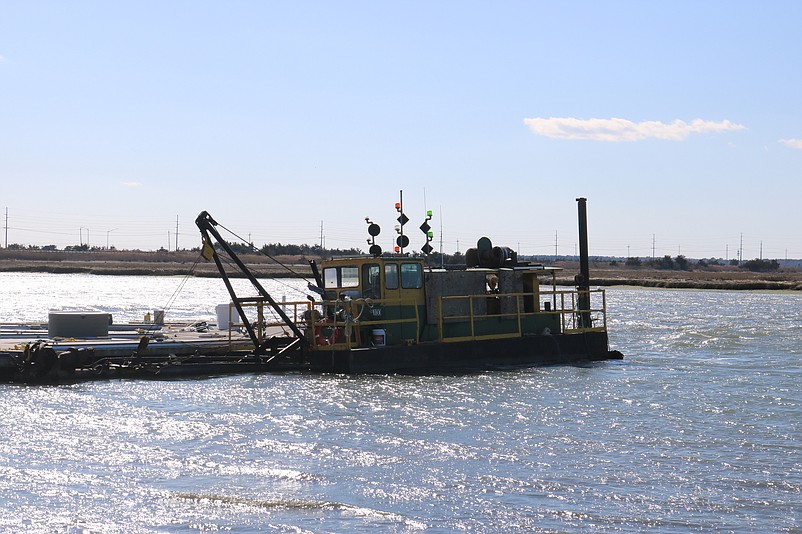 A barge-like dredge is moored in the bay at the end of Sounds Avenue near 38th Street.