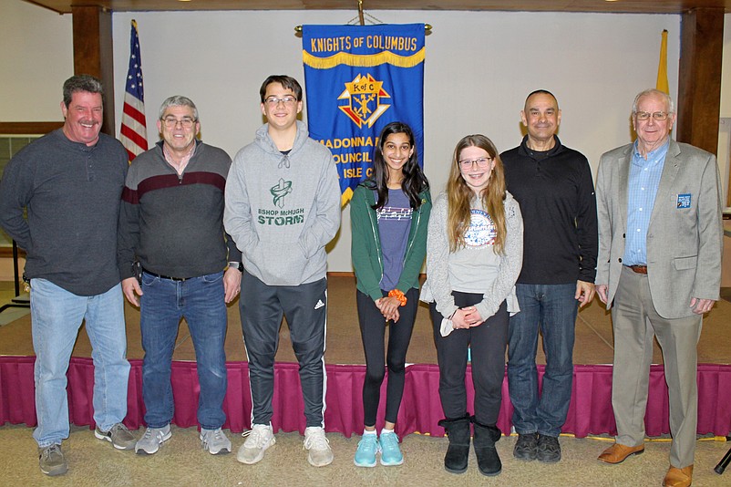 The event’s winners, in center, were Benjamin Harczak, Khushbu Pandya and Annabelle Robine. From left, Spelling Bee judges Ron Custer, Alex Iannone, moderator Mike Jargowsky and judge Mike McHale. (Photo courtesy of Sea Isle City)