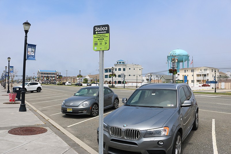 Green signs like this one on John F. Kennedy Boulevard explain how to use the mobile app for parking payments.