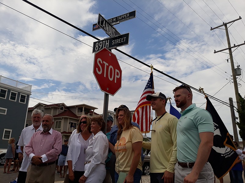 Judi Tapper, center, is joined by members of her family and Mayor Leonard Desiderio underneath the new street honoring her son.