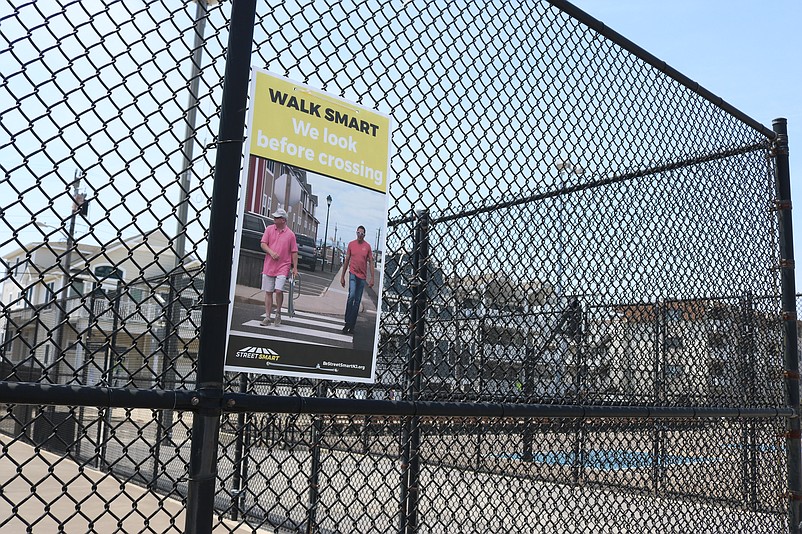 A sign attached to a playground fence on JFK Boulevard stresses the importance of pedestrian safety.