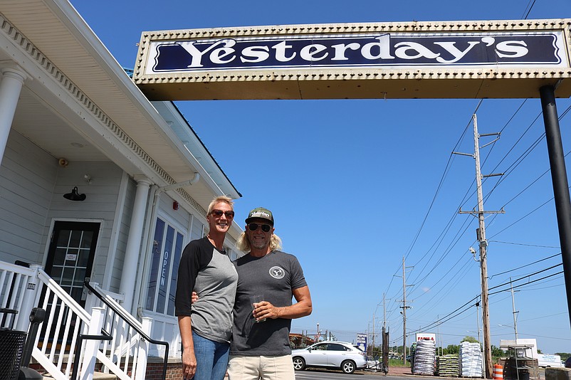 Yesterday's Creekside Tavern owner Tim Fox and his partner, Robyn Kjar, stand underneath the restaurant's iconic sign.