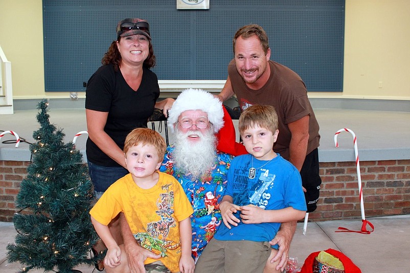 Christmas in July is returning to Excursion Park. Lisa and Mike Rutledge, along with their children, Joe and Nick, celebrate with Santa during the event several years ago. (Photo courtesy of Sea Isle City)